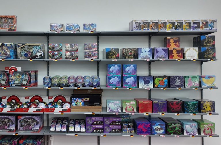 PokeZone Sammelkarten und Merch Bunte Regale mit Spielzeug, Spielen und Sammelkarten in einem Laden.